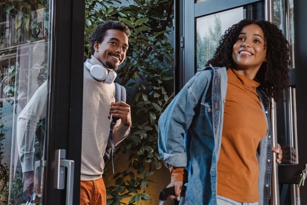Two smiling guests arriving at a property with luggage
